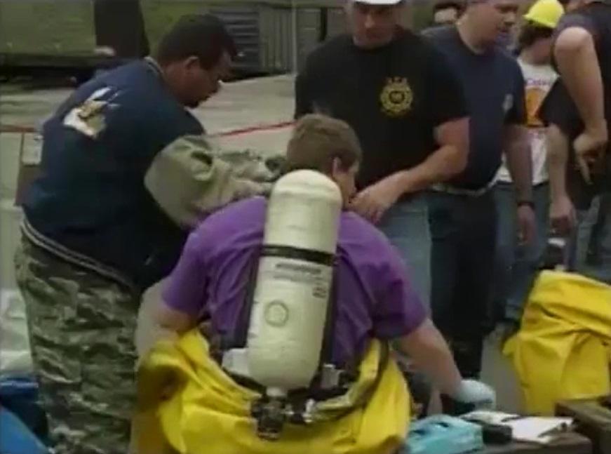 First Responders practice donning and doffing personal protective equipment at a training exercise. This is a screenshot of footage from one of our HAZWOPER titles.